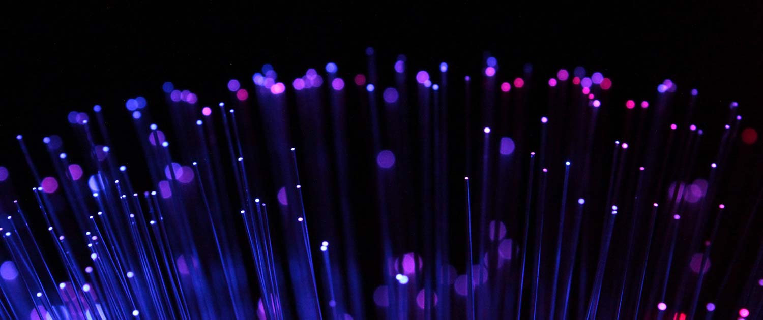 DC Fibr. Extremo de filamentos de fibra iluminados formando destellos.